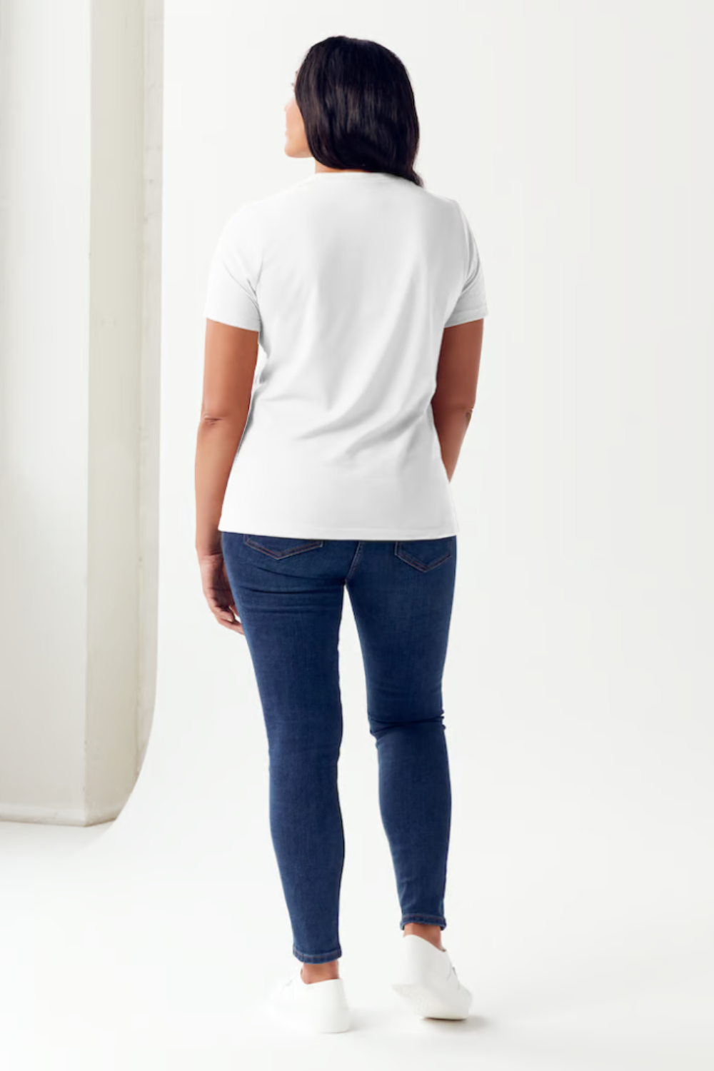 A person is wearing a Simply Love Full Size Slogan Graphic Short Sleeve Tubular T-Shirt, featuring a minimalist design of two hands reaching for each other. The text reads: "See the good in yourself and in others," delivering a positive message to all who see it.