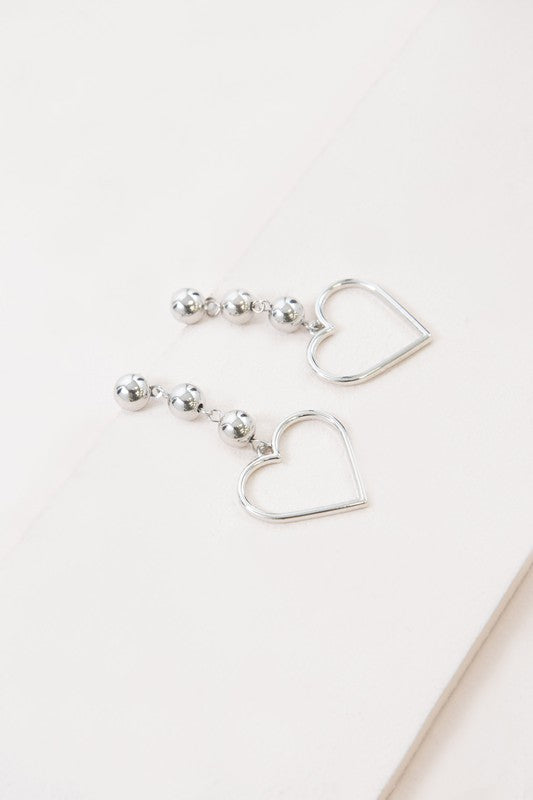 Pair of It's a Fling Drop Earrings dangle on a white surface.