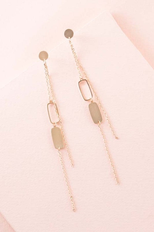 Absolutely Alluring Dangle Earrings with geometric shapes on a pink background.