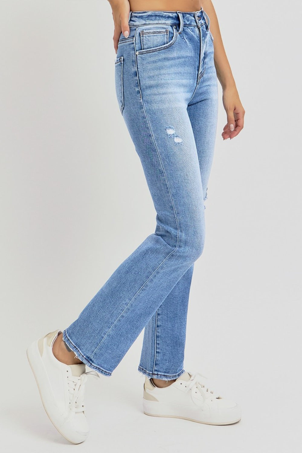 Person wearing RISEN Full Size Distressed High-Rise Ankle Straight Jeans in light blue paired with white sneakers.