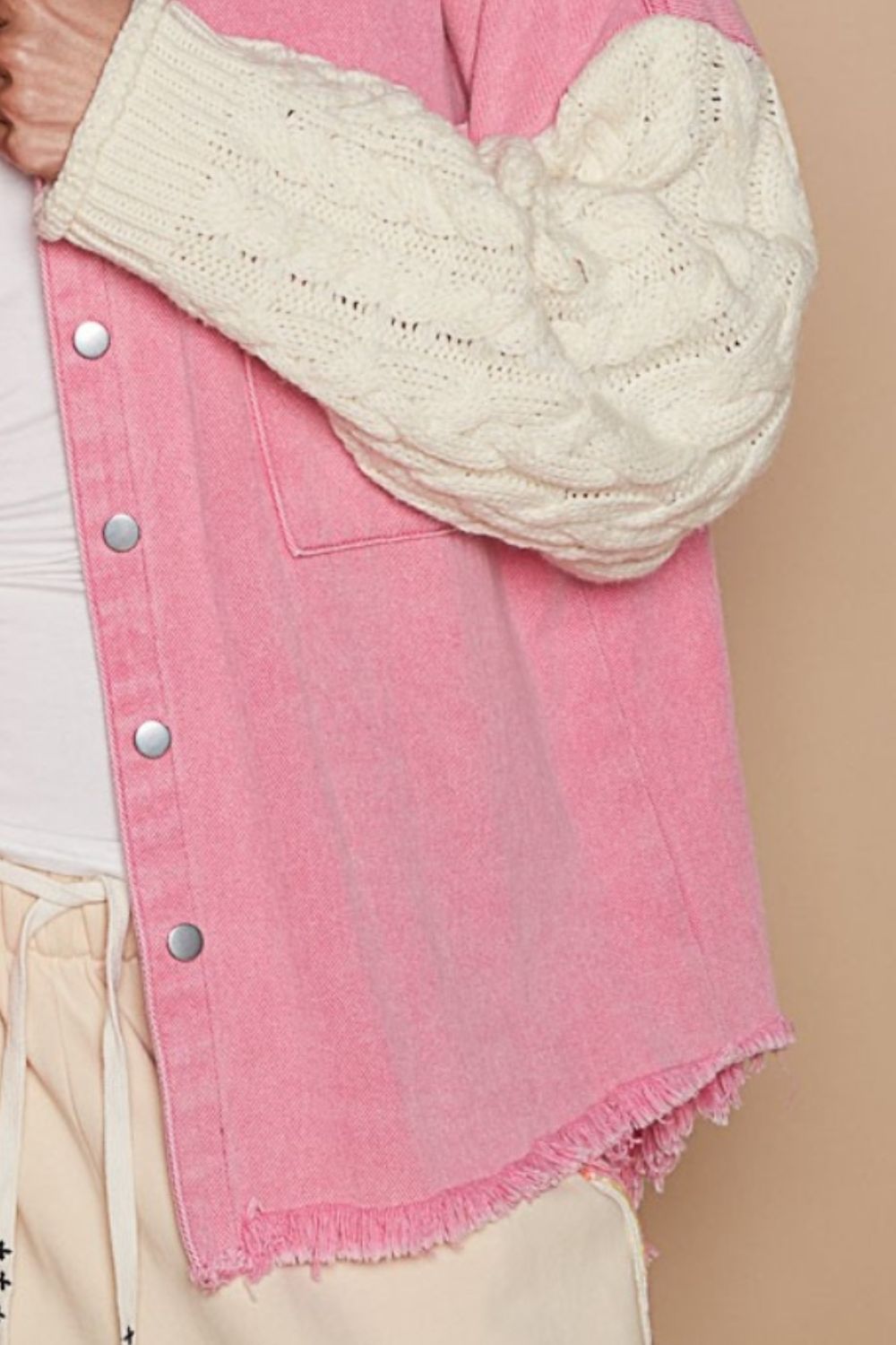 A trendy outfit showcases the POL Contrast Sweater Sleeve Button Down Shacket in pink, complete with knitted white sweater sleeves, paired with beige pants and set against a subtle beige background.