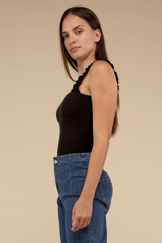 A young woman in a chic Ribbed Ruffle Strap Bodysuit and ripped denim shorts poses against a plain background.