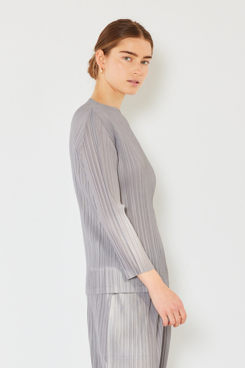 A person wearing the Marina West Swim Pleated Long Sleeve Boatneck Top with matching pants stands against a plain background.