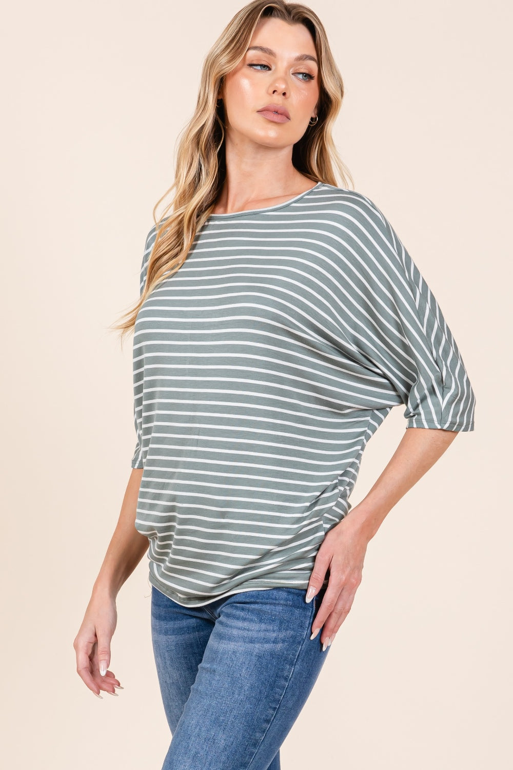 A person with long, wavy hair wearing the BOMBOM Striped Boat Neck Dolman Sleeve Top and blue jeans poses against a plain background.