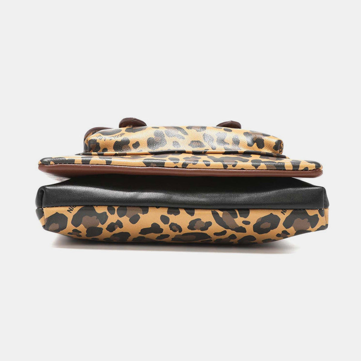 The Nicole Lee USA Leopard crossbody bag is made from vegan leather and showcases a leopard print design. It features a front pocket, a zippered closure, gold-tone hardware, brown trim, and a black panel at the top that is embellished with a brand label.