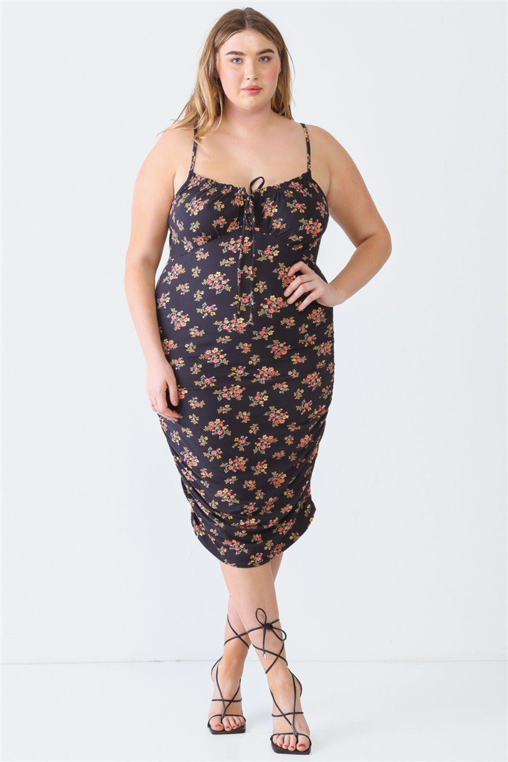 A woman stands against a white background wearing a Blue Leopard Plus Size Ruched Floral Square Neck Cami Dress with strappy high-heeled sandals, perfect for a summer day out.