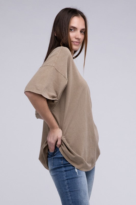 A person with long hair wearing an Oversized T-Shirt in beige with short sleeves and blue jeans, standing against a neutral background.