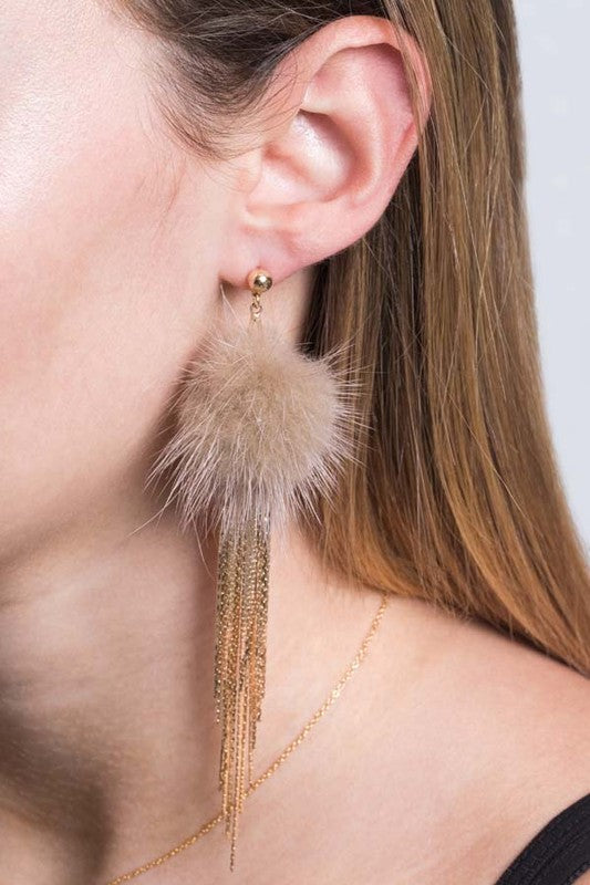 Side view of a person wearing a fluffy, gold Powder Puff Drop Earring.