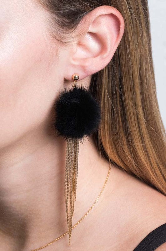 Side view of a person wearing a fluffy, gold Powder Puff Drop Earring.