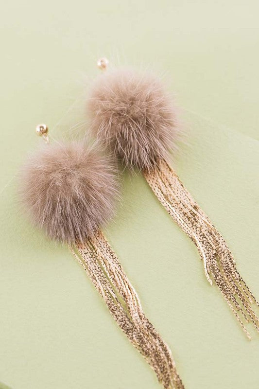 Side view of a person wearing a fluffy, gold Powder Puff Drop Earring.