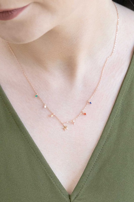 A delicate Serenade Necklace with star-shaped pendants and multi-colored stones, crafted in 14K rose gold over stainless steel.