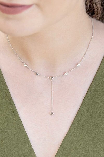 The Falling in Love lariat necklace with evenly spaced embellishments on a white background.