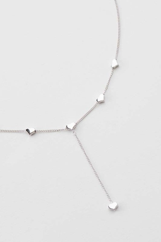 The Falling in Love lariat necklace with evenly spaced embellishments on a white background.