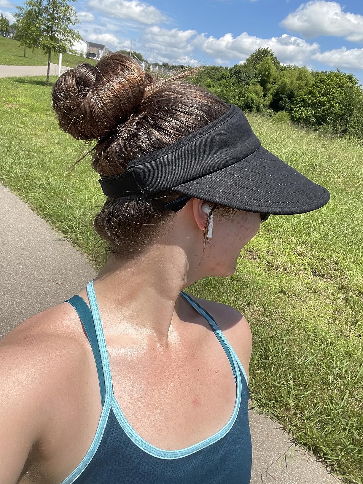 Woman wearing a Sun Visor Hats Women Large Brim Summer UV Protection Beach Cap and sunglasses, styled with a white t-shirt and ponytail, looking to the side against a white background.