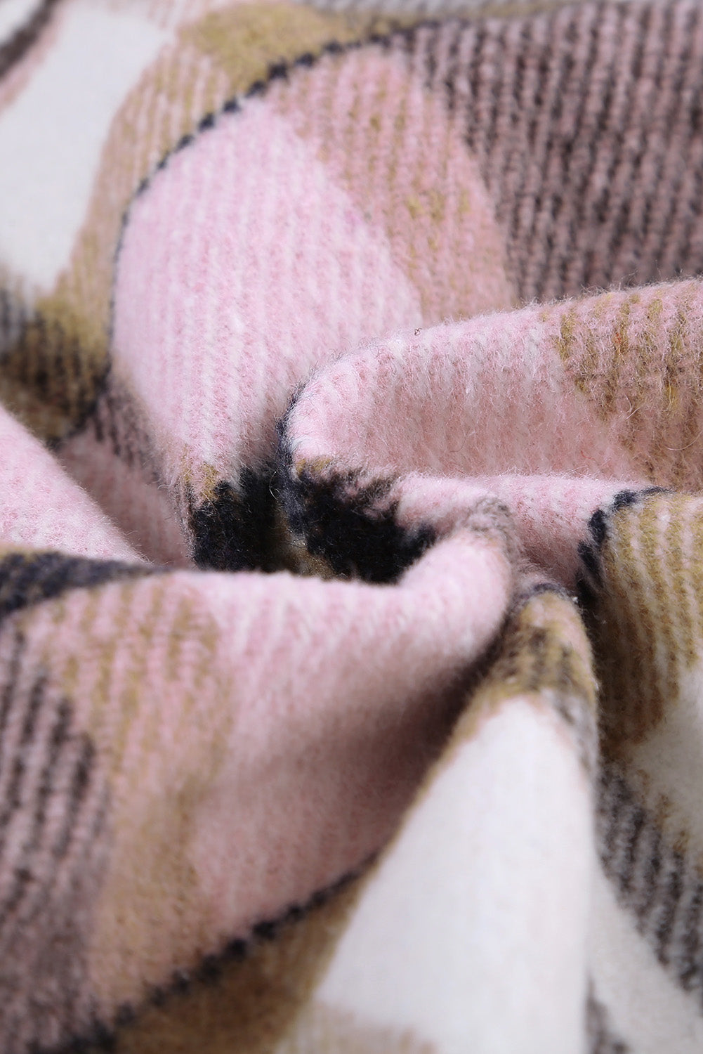 A person wearing a Brown Plaid Button Up Long Sleeve Flannel Shacket layered over a white top with ripped jeans and holding a brown handbag stands against a textured gray wall.