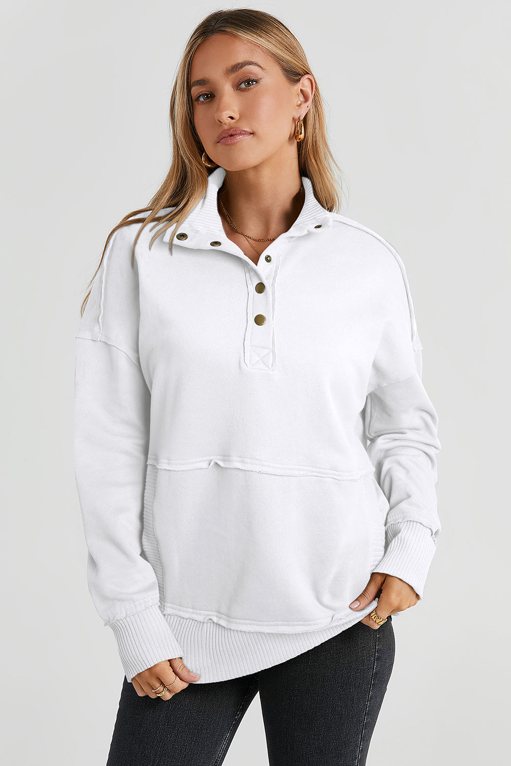 A woman with long hair wearing a White Ribbed Hem Snap Button Neckline Sweatshirt with Pocket is seen from behind, standing against a plain background, embodying a casual look.