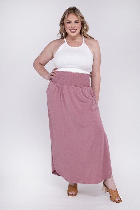 A person wearing a white top and the Plus Smocked Waist Side Slit Maxi Skirt w/ Pockets stands with crossed legs, showcasing tan heels.