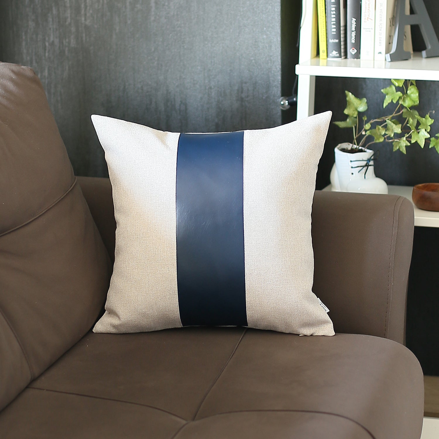 In a well-lit room, a black wire chair is tastefully adorned with a Boho Handcrafted Decorative Single Throw Pillow Cover in beige and brown, featuring vegan faux leather.