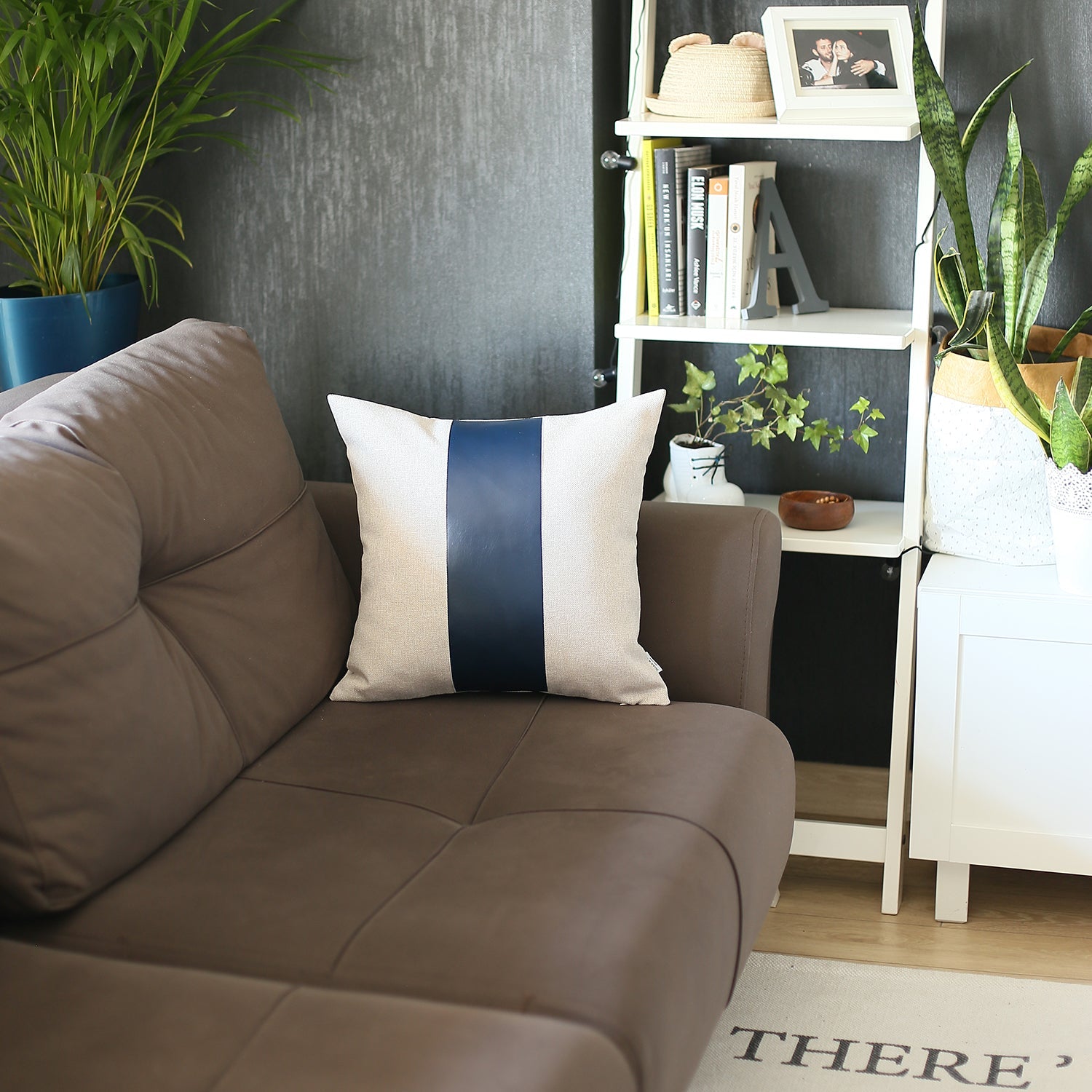In a well-lit room, a black wire chair is tastefully adorned with a Boho Handcrafted Decorative Single Throw Pillow Cover in beige and brown, featuring vegan faux leather.