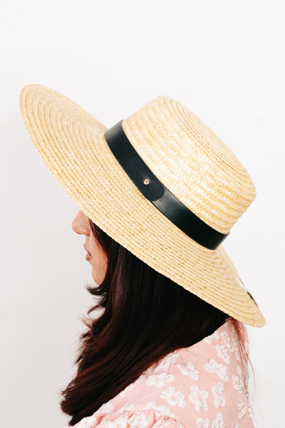 The Fame Flat Brim Straw Weave Hat, showcased against a white background with its stylish black band around the crown, makes for the perfect summer accessory.