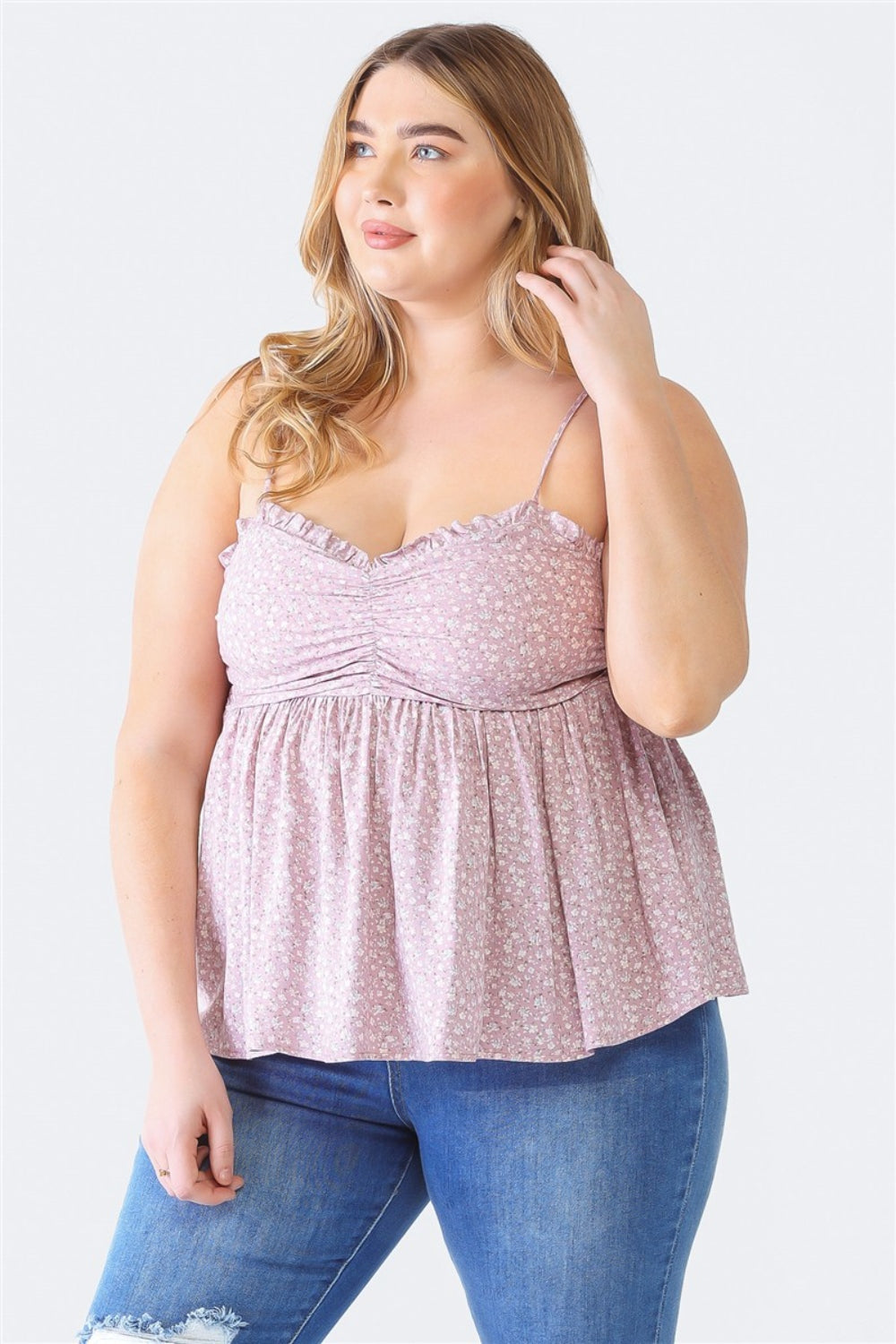 A woman stands facing the camera wearing a Zenobia Plus Size Frill Smocked Floral Sweetheart Neck Cami with dark jeans, against a plain background.