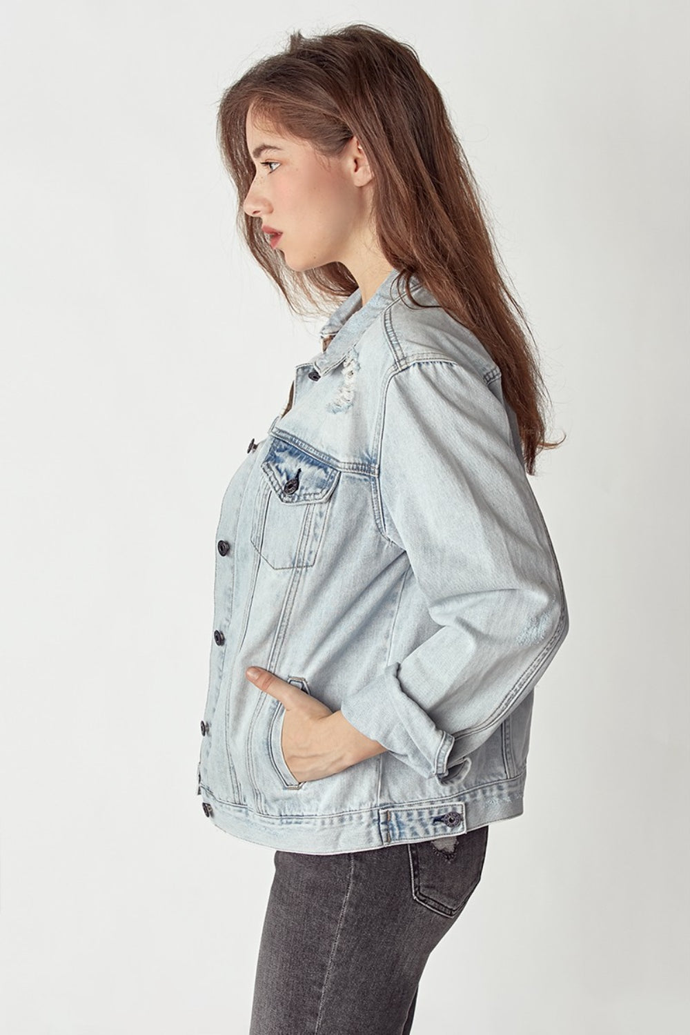 A person wearing the RISEN Distressed Button-Up Jacket with rolled-up sleeves, posing against a plain background.