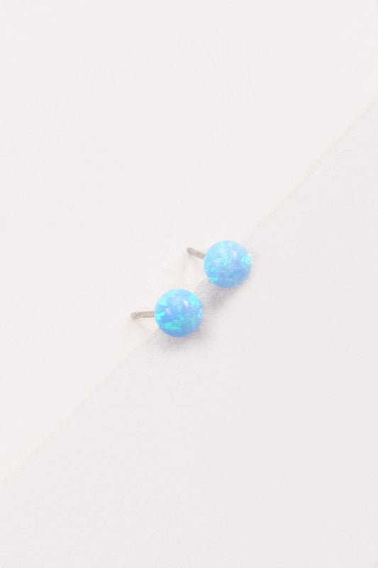 Five Tiny Sphere stud earrings arranged in a line on a pale background.