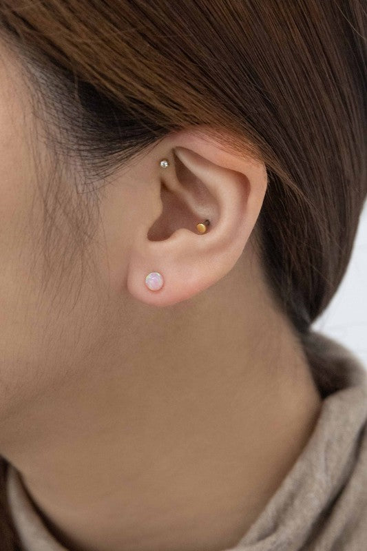 Five Tiny Sphere stud earrings arranged in a line on a pale background.