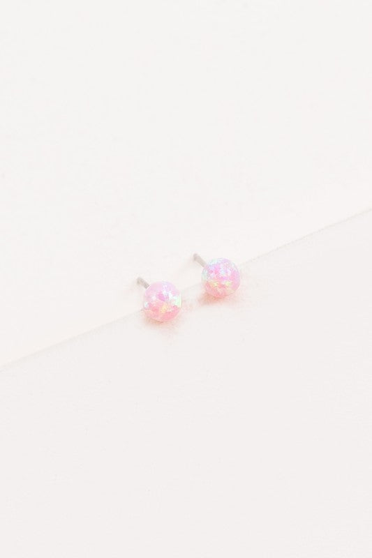 Five Tiny Sphere stud earrings arranged in a line on a pale background.