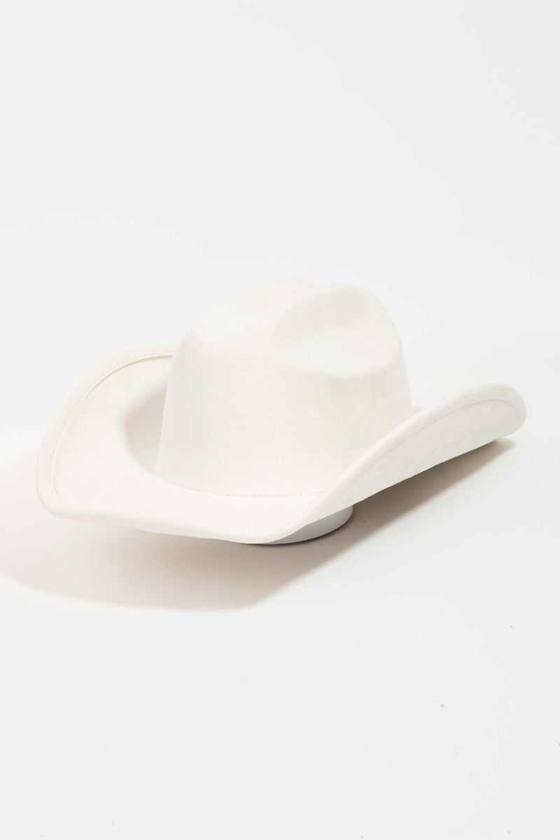 The Fame Solid Wide Brim Hat, showcasing a classic western style with its wide brim and creased crown, sits elegantly on a white surface.