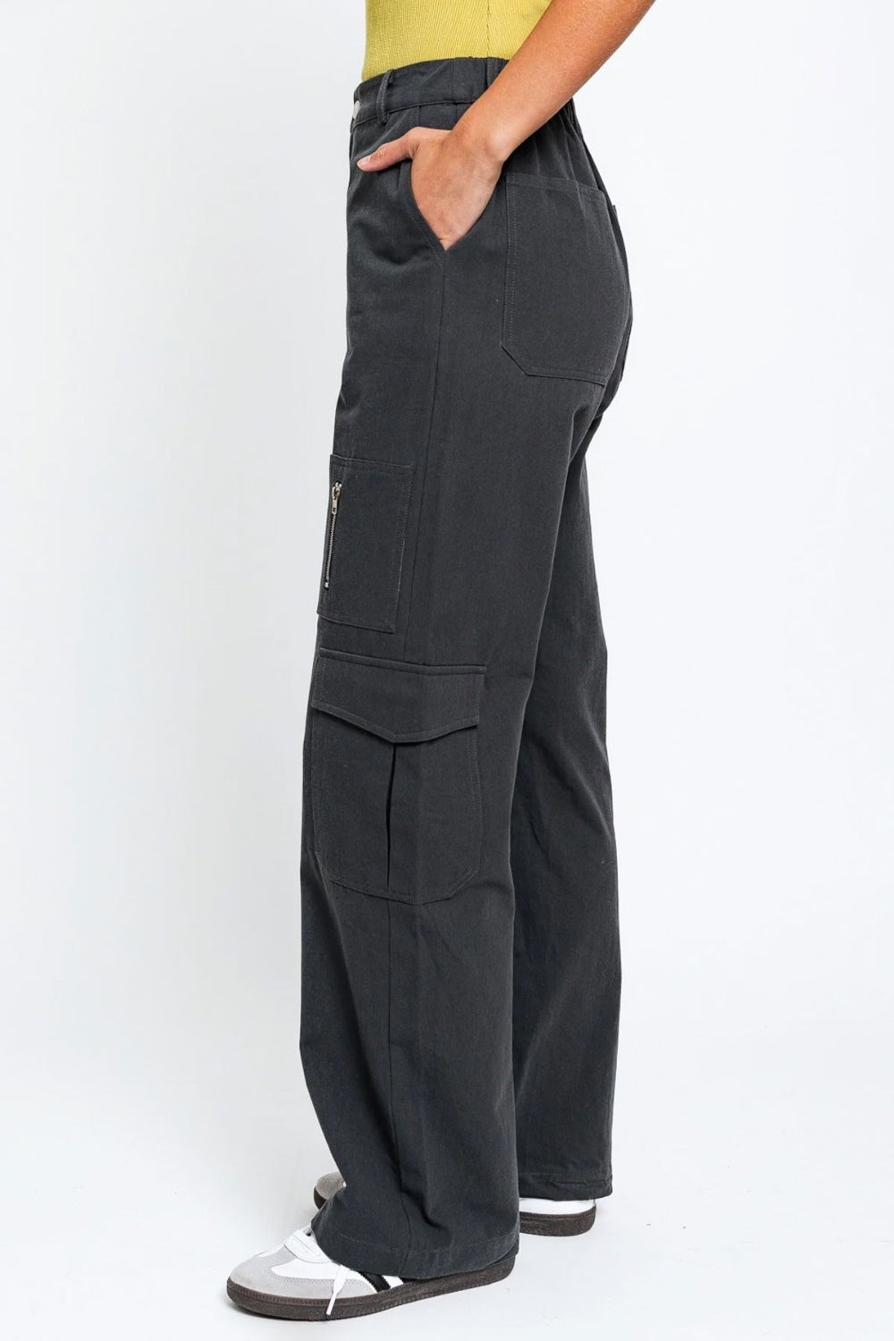   Person wearing the Le Lis High Waisted Wide Leg Cargo Pants with Pockets, featuring side pockets and zipper details, standing against a plain white background.