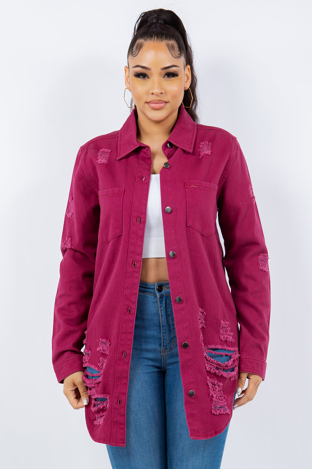 Person wearing an American Bazi Distressed Button-Up Long Sleeve Denim Jacket in pink over a white crop top and blue jeans, posing against a plain background.