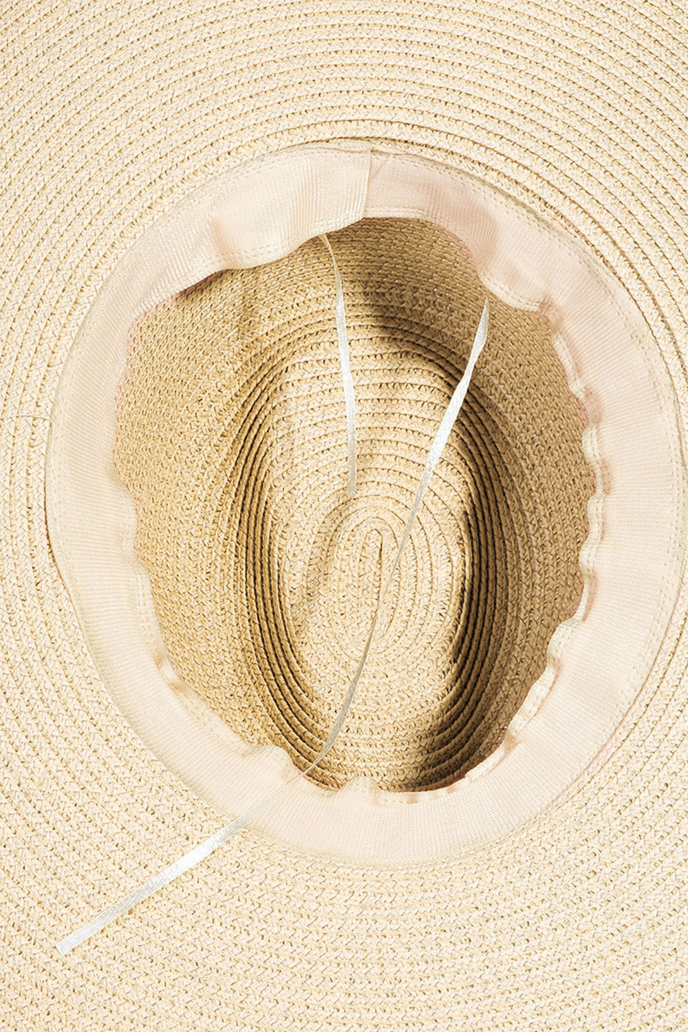 The Fame Geometric Raw Hem Hat is a stylish wide-brimmed straw hat, adorned with a red and beige geometric patterned band, making it the perfect fashionable accessory.