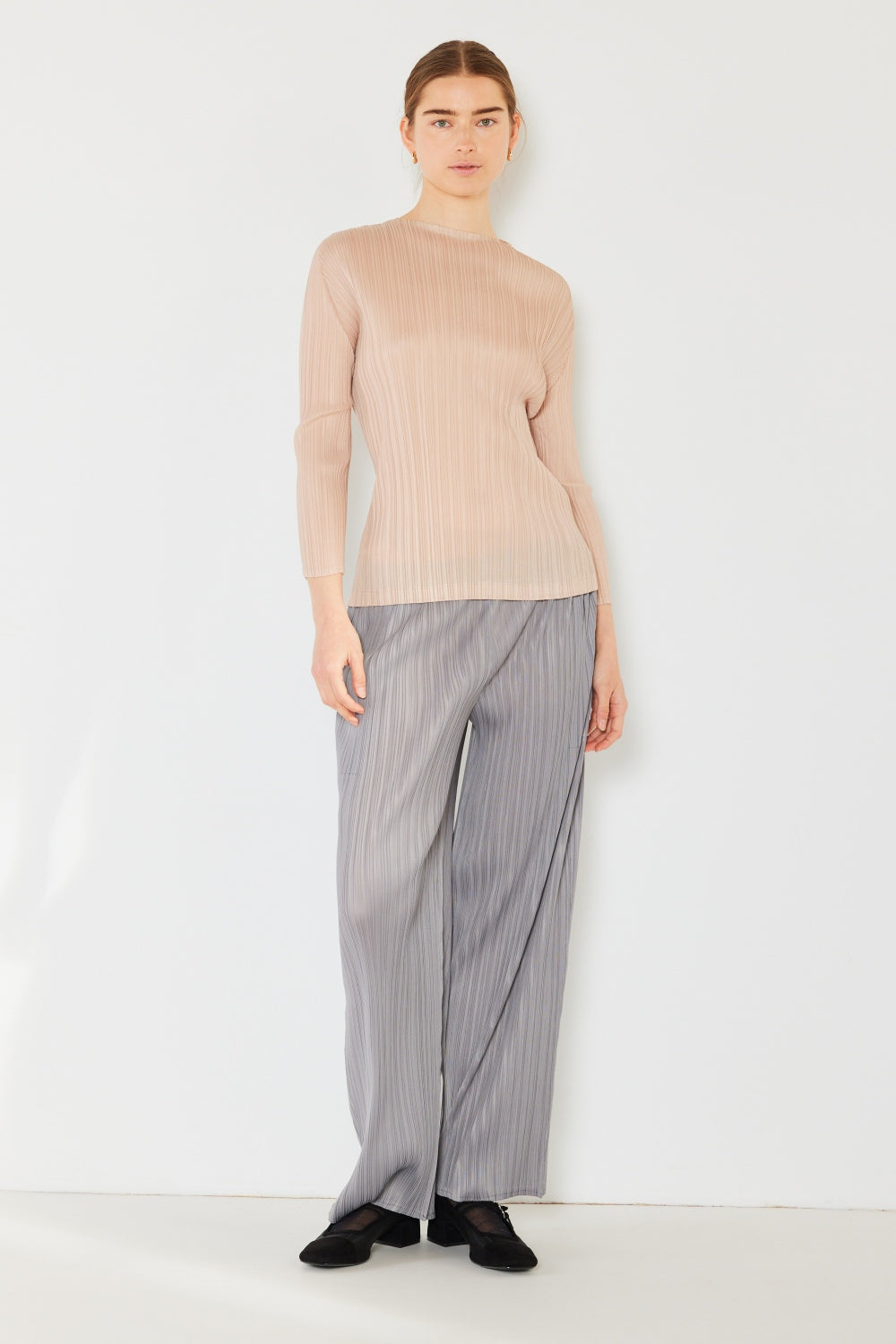 A person wearing the Marina West Swim Pleated Long Sleeve Boatneck Top with matching pants stands against a plain background.