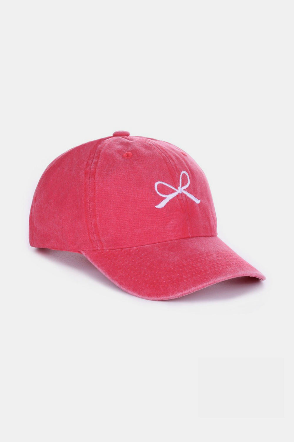 The Zenana Bow Embroidered Washed Cotton Cap features a pink design with a stylish white bow on the front, set against a plain, light background. This chic accessory seamlessly combines elegance and sportiness.