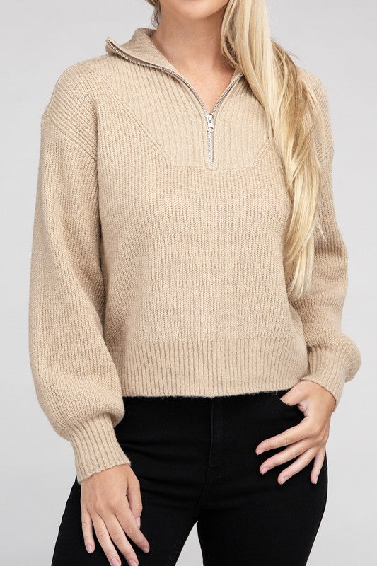 A person with long blonde hair wears a stylish cozy top—an Easy-Wear Half-Zip Pullover in grey—and blue jeans while looking down.