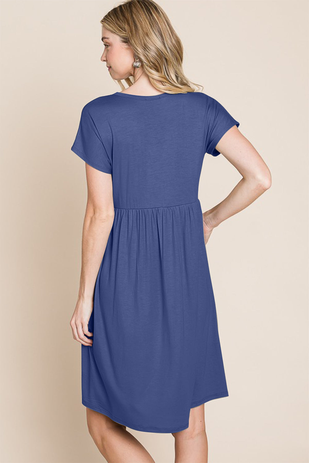 The BOMBOM V-Neck Short Sleeve Dress, crafted from soft rayon spandex fabric, showcases a blue hue with short sleeves and distinctive button accents.