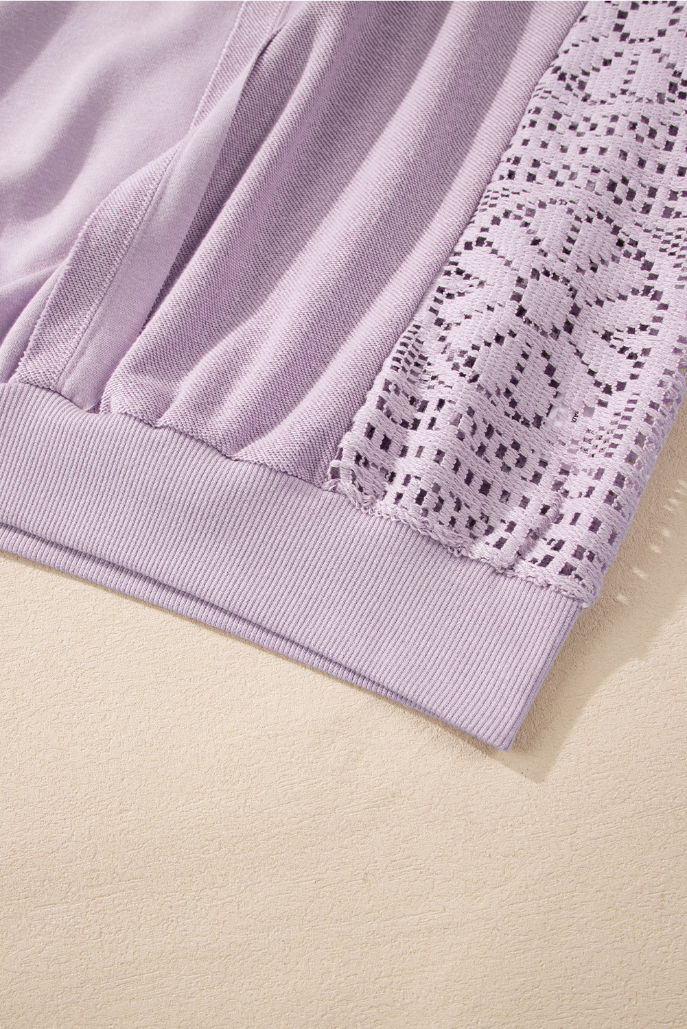 A person with long hair is seen from the back wearing the Orchid Petal Knit Crochet Exposed Seam Ribbed Trim Sweatshirt, blue jeans, and a brown crossbody bag.