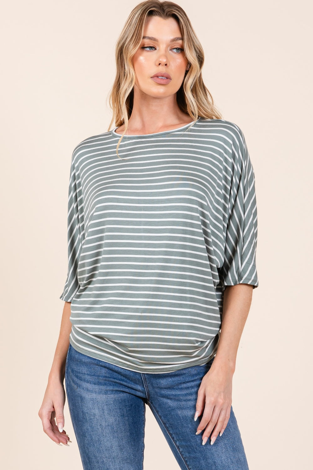 A person with long, wavy hair wearing the BOMBOM Striped Boat Neck Dolman Sleeve Top and blue jeans poses against a plain background.