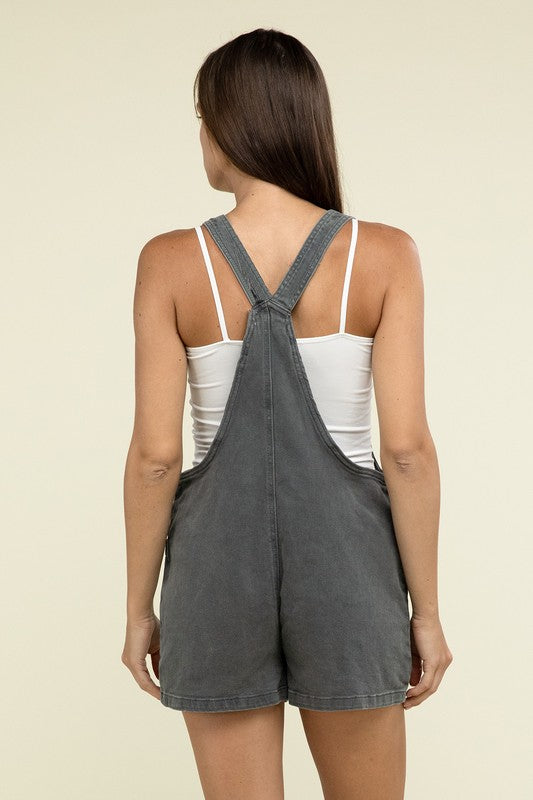 A person wearing the Washed Knot Strap Romper and a white tank top stands against a plain background.