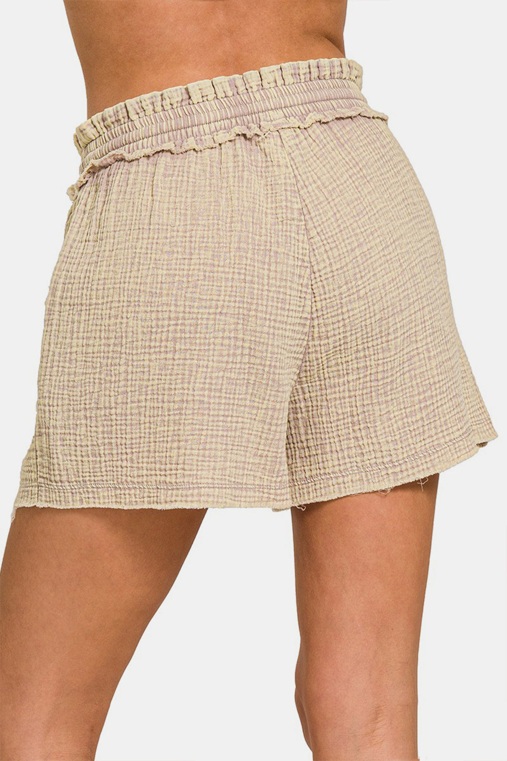 The person is wearing the Zenana Washed Frayed Hem Drawstring Shorts, featuring a light beige hue and textured cotton fabric, ideal for any summer wardrobe.