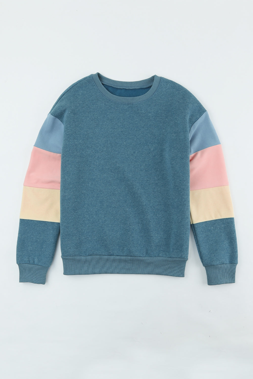 A rear view of a person with wavy hair, dressed in a Blue Colorblock Long Sleeve Pullover Sweatshirt and light blue jeans, hands resting on their hips. Perfect for winter fashion, this versatile piece is an ideal addition to any wardrobe.