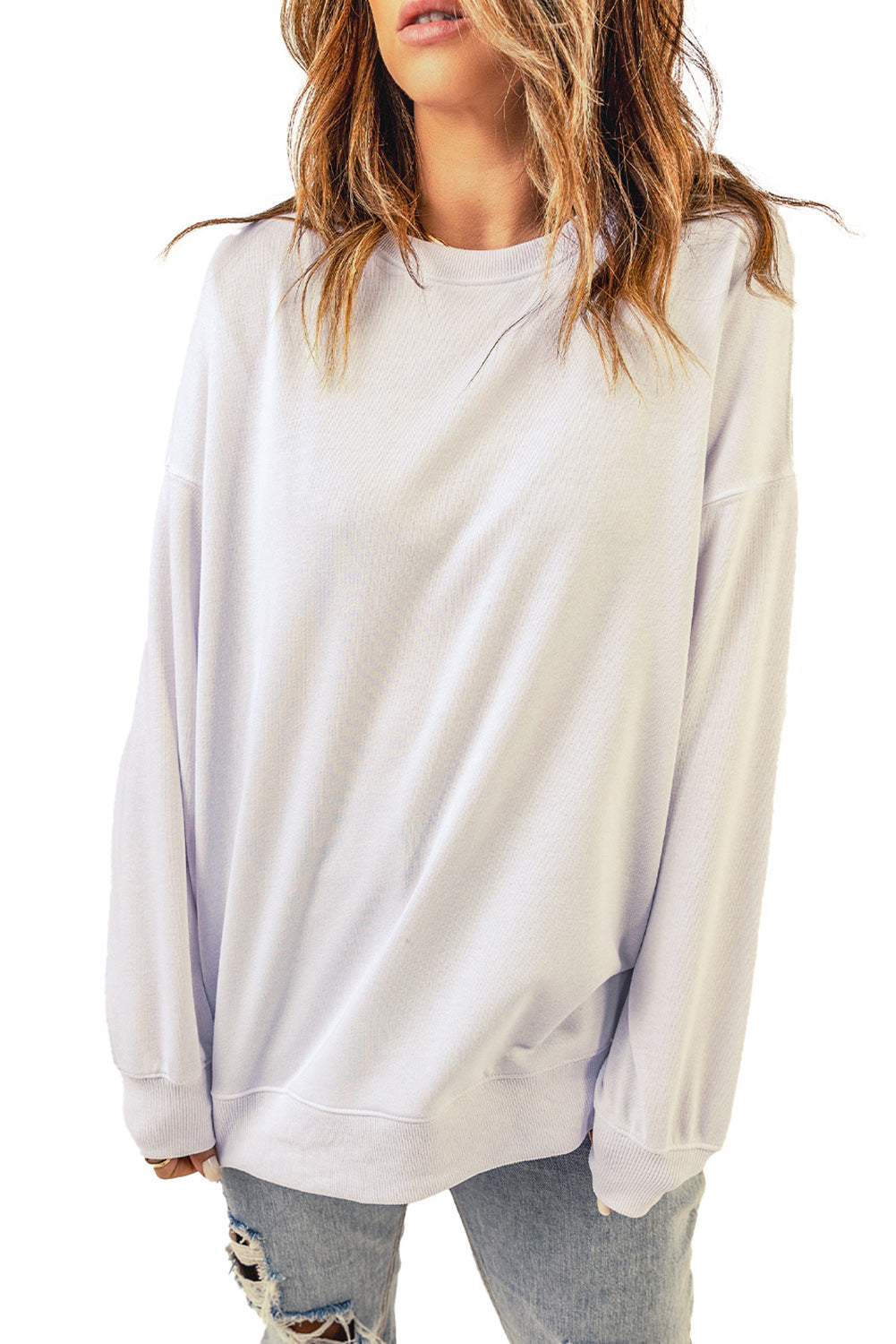 A person wearing a White Oversized Solid Drop Shoulder Sweatshirt and distressed blue jeans is shown from the back, with wavy, shoulder-length hair.