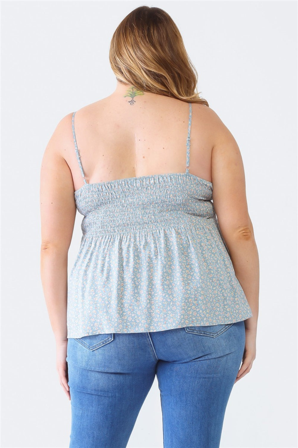 A woman stands facing the camera wearing a Zenobia Plus Size Frill Smocked Floral Sweetheart Neck Cami with dark jeans, against a plain background.