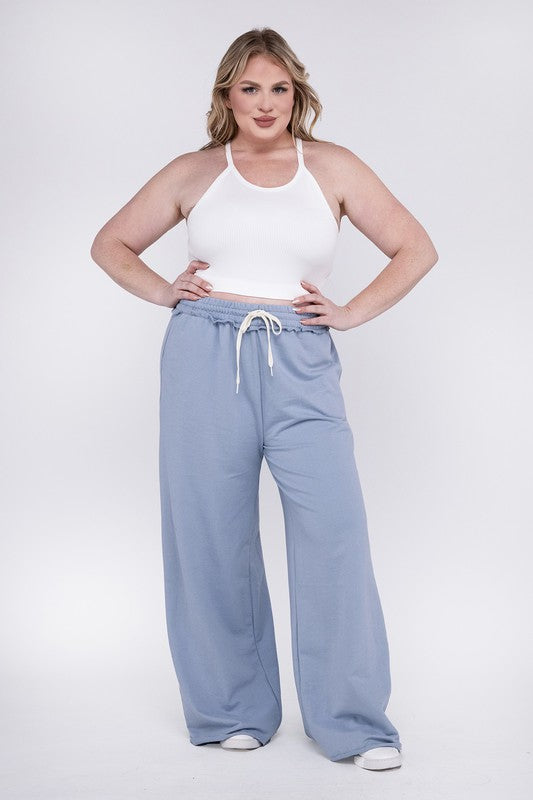 A person wearing the Plus F/Terry Drawstring Waist Raw Edge Hem Pants in pink, paired with white shoes, stands against a plain background.