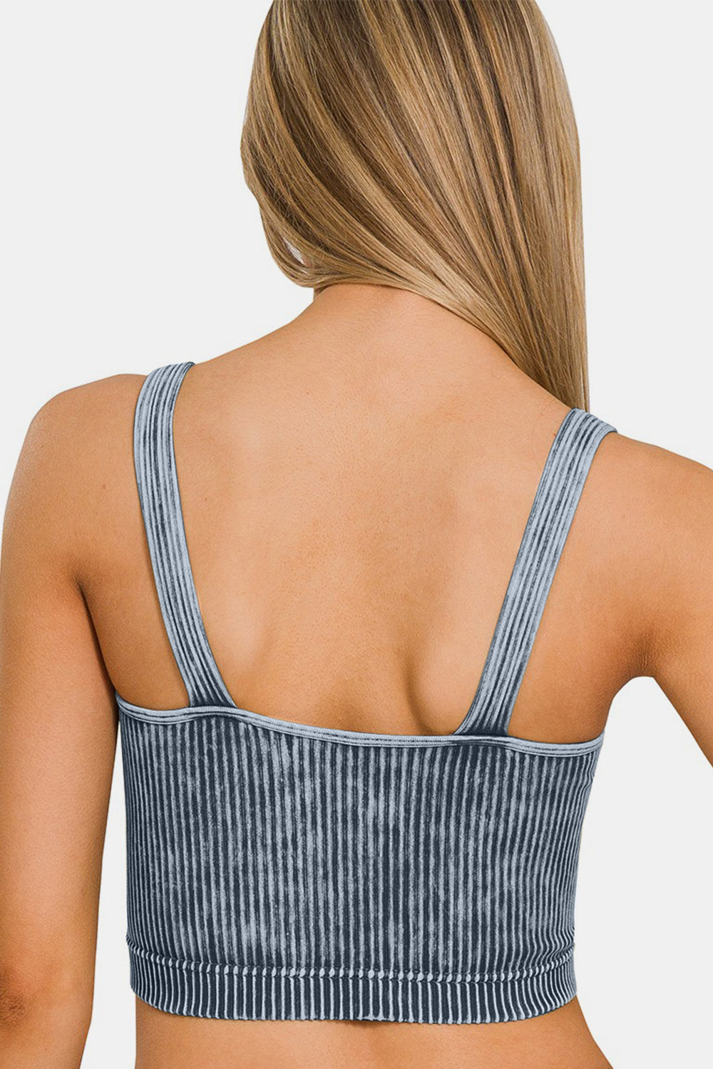 A woman with long blonde hair is wearing a trendy Zenana washed ribbed cropped V-neck tank.