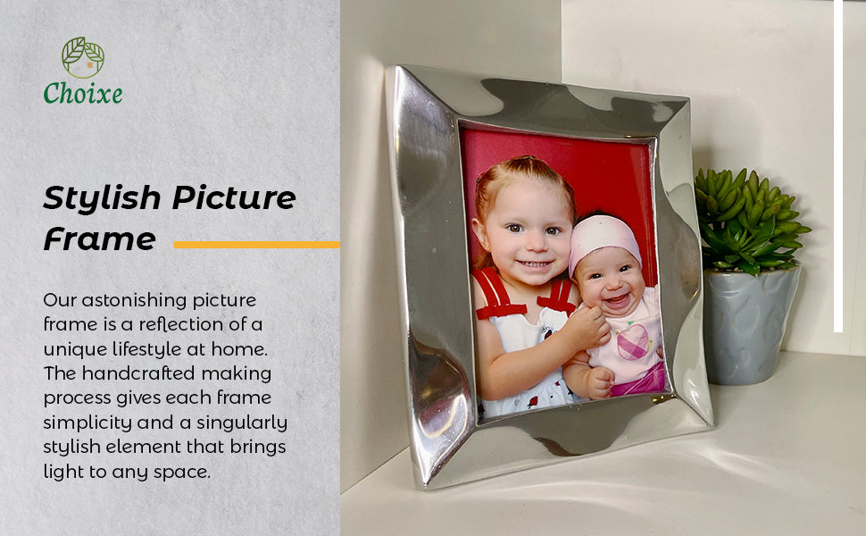 The Stylish Picture Frame is a minimalist design crafted from recycled aluminum, showcasing a silver finish with a plain brown backing and supported by a wooden stand at the back.