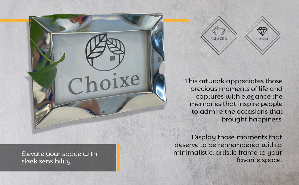 The Stylish Picture Frame is a minimalist design crafted from recycled aluminum, showcasing a silver finish with a plain brown backing and supported by a wooden stand at the back.