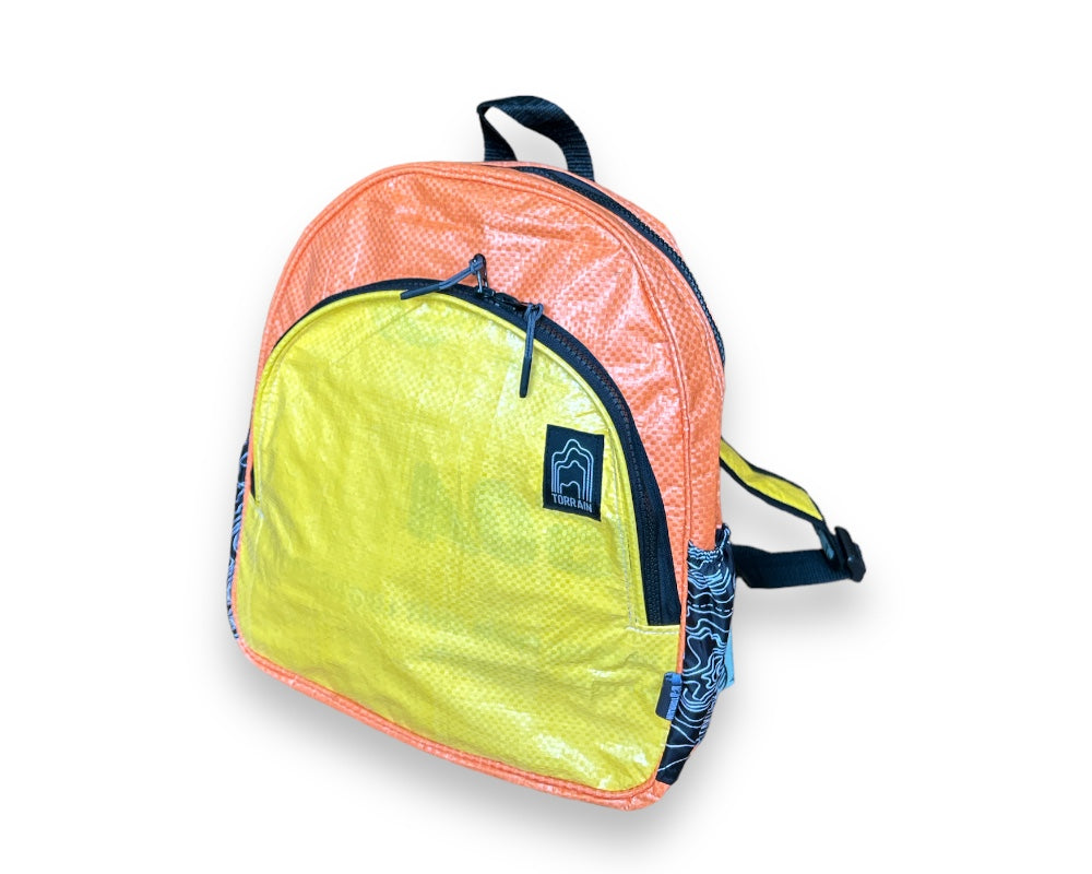 Introducing the Scout Backpack: a chic day pack that features a topographic pattern crafted from upcycled materials, with a vibrant yellow front, an orange top, and sleek black sides, all set against a pristine white background.