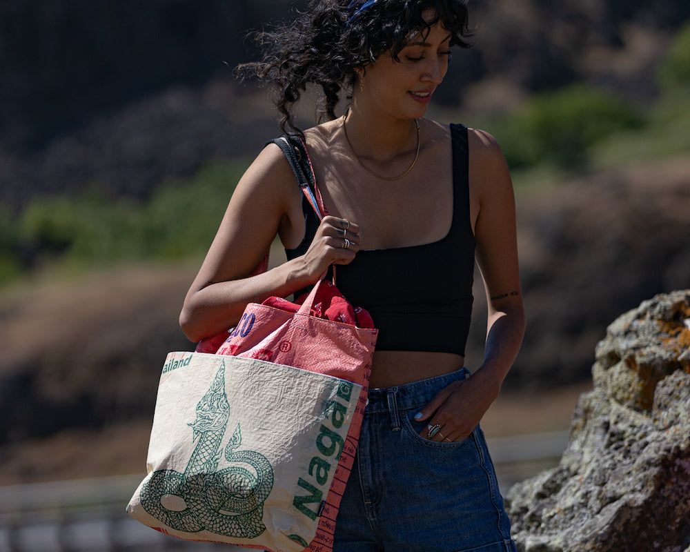 This lively Barrel Tote, made from recycled rice sacks, features whimsical frog graphics and genuine Vietnamese text, embodying a Portland-inspired design.